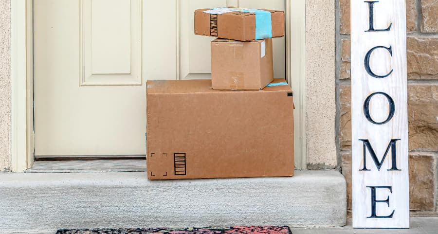 Packages on the doorstep of a home with a welcome sign in Champaign